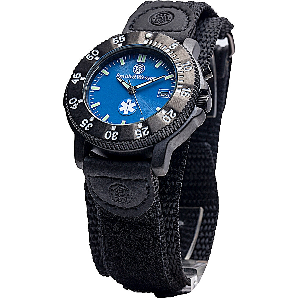 Smith & Wesson Paramedic EMT watch with blue glowing dial, Japanese quartz movement, black nylon strap, and Star of Life EMS design.